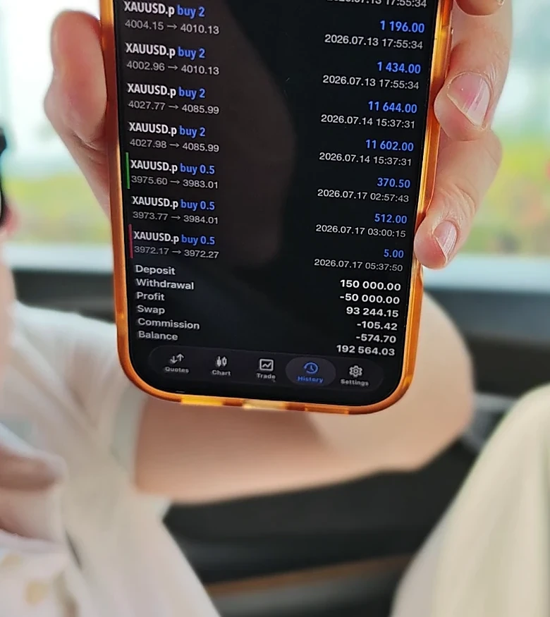 Su holding up his phone with his trading history